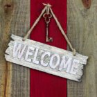 Welcome sign with skeleton key hanging on red wood door