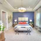 Master suite with neutral tones and cool blues with a red accent and great outdoor view