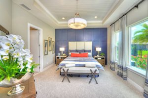 Master suite with neutral tones and cool blues with a red accent and great outdoor view